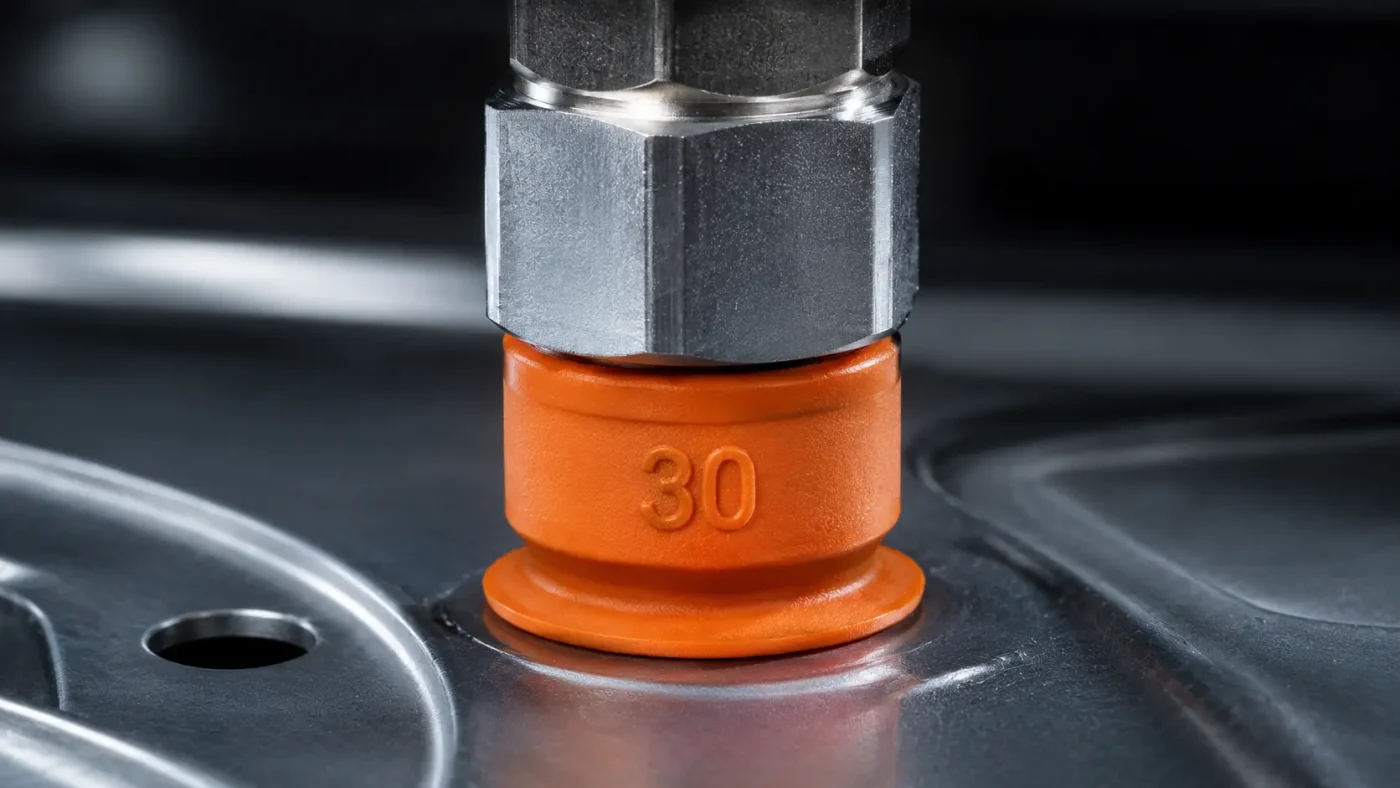 Close-up suction cup bellow vacuum yang menghisap dan mengangkat panel logam di lini produksi